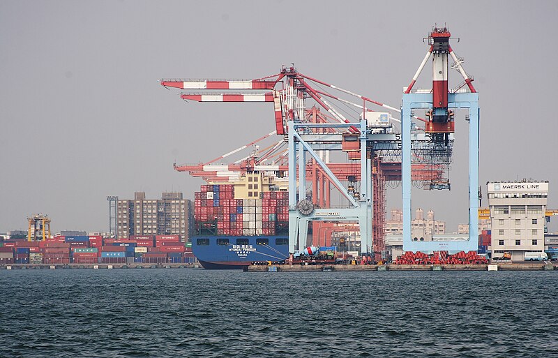 Shipping containers at a port as tariff headlines pressure risk assets like crypto.